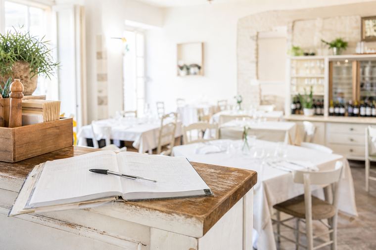 Una donna al banco di un locale, dietro il piano di servizio dove si accolgono i clienti
